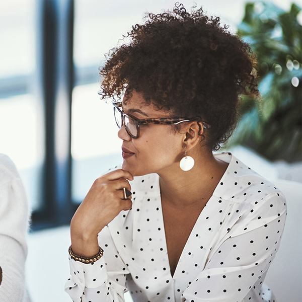A young woman of color listening to a co-worker
