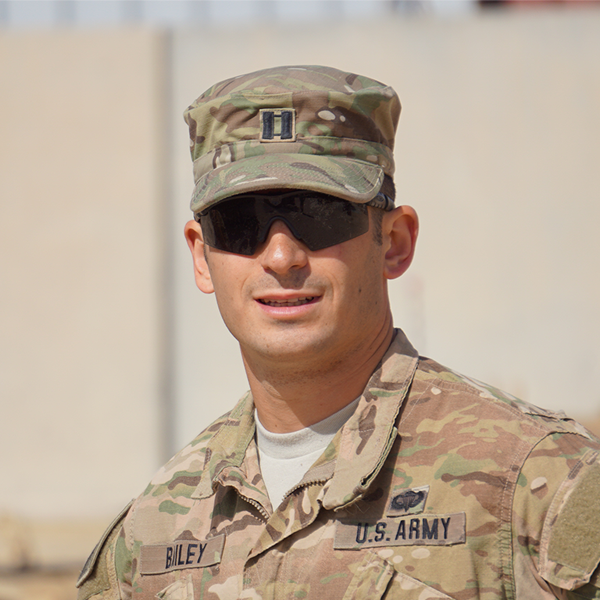 A smiling male veteran wearing Army fatigues