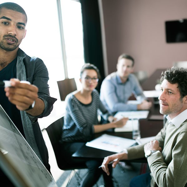 Man presenting to a table of people in a conference room