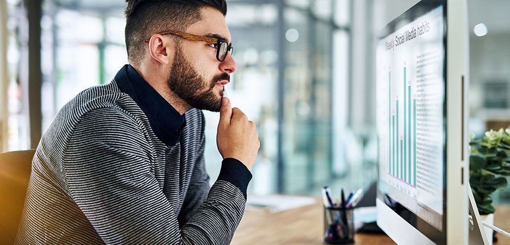Younger man looking at a computer screen