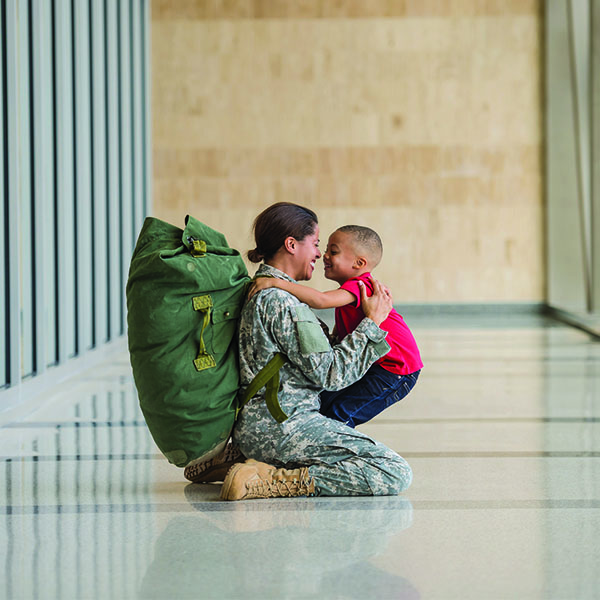 Military woman hugging young boy