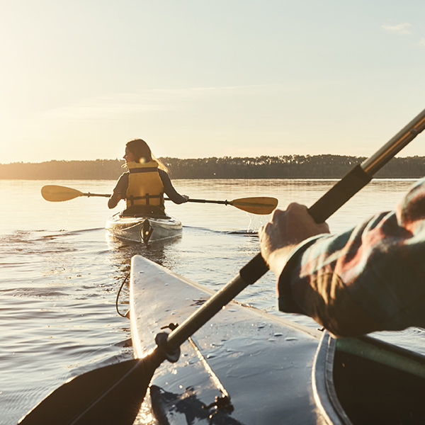 Two people kayaking on a calm mountain lake