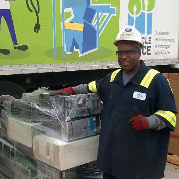 A man standing in front of a recycling truck with electronics