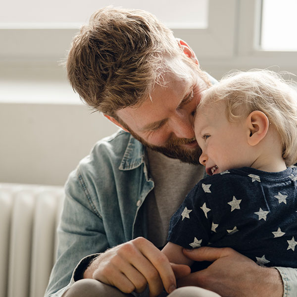 A father holding a young child in his lap