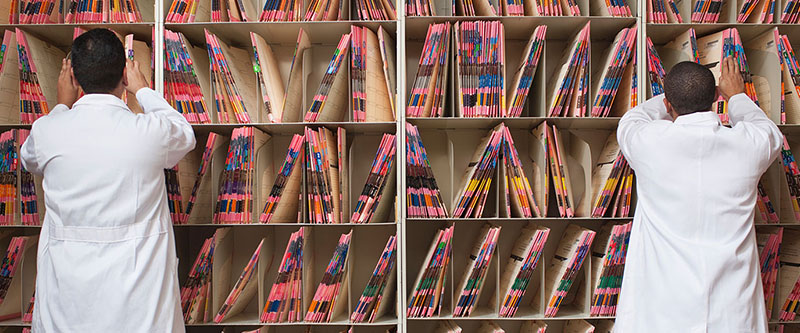 Doctors looking through files cabinets