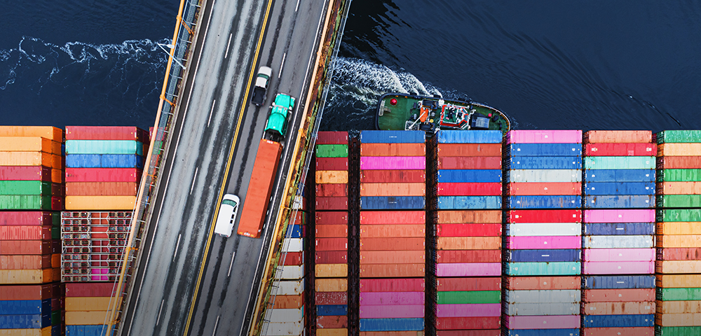 Cargo ship passing underneath bridge
