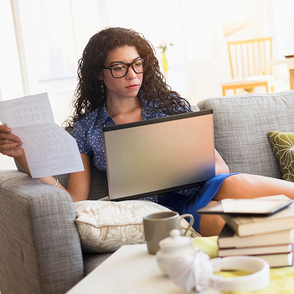 Woman sitting on a couch with a laptop