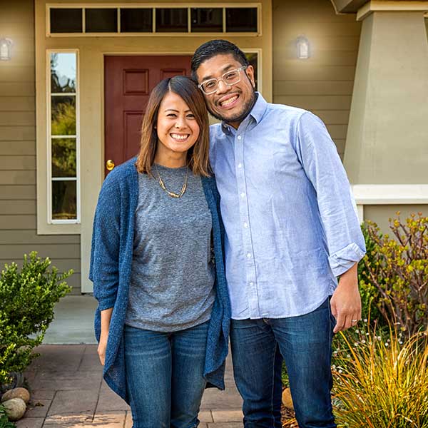 Man and woman standing in front of new home