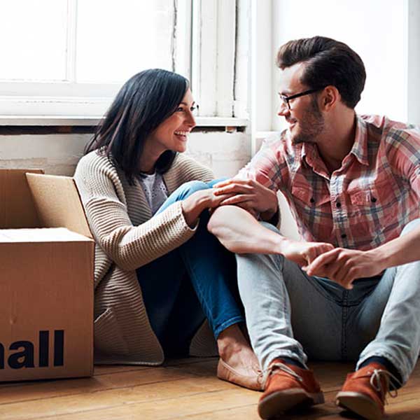 man and woman sitting by packing boxes