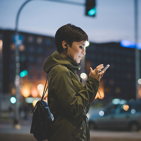 A woman holding a smartphone on a city street