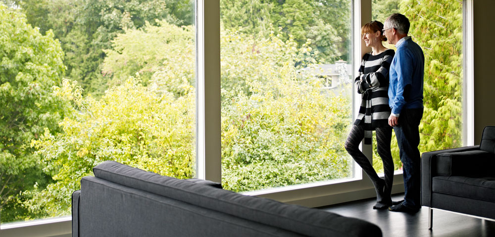 man and woman looking out large window