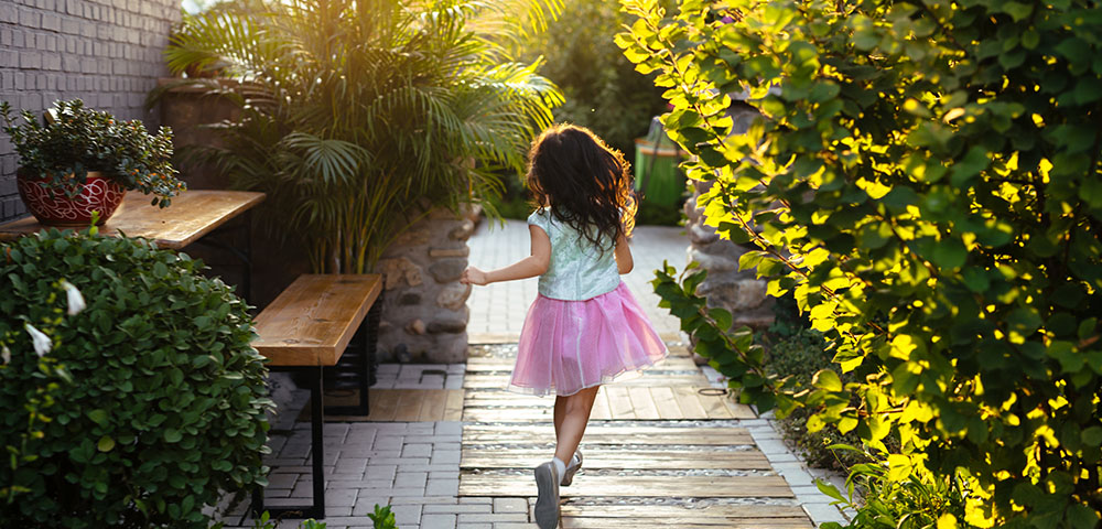 little girls skipping on path