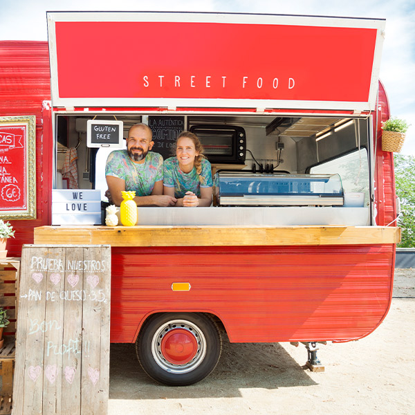 smiling couple inside a red food truck