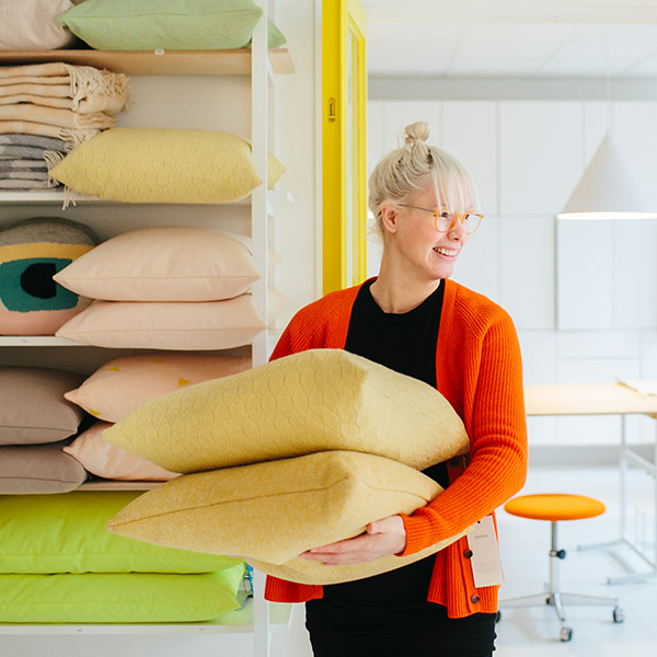 Woman carrying two decorative pillows