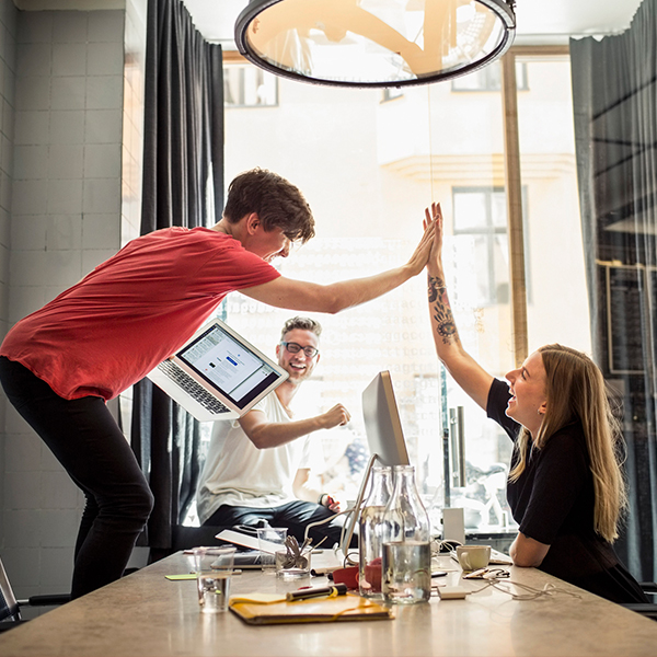 coworkers high-fiving in celebration