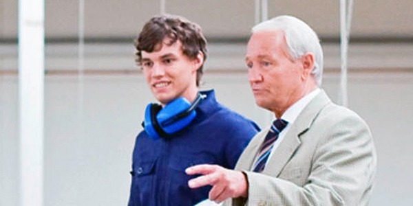 two men overlooking a factory floor